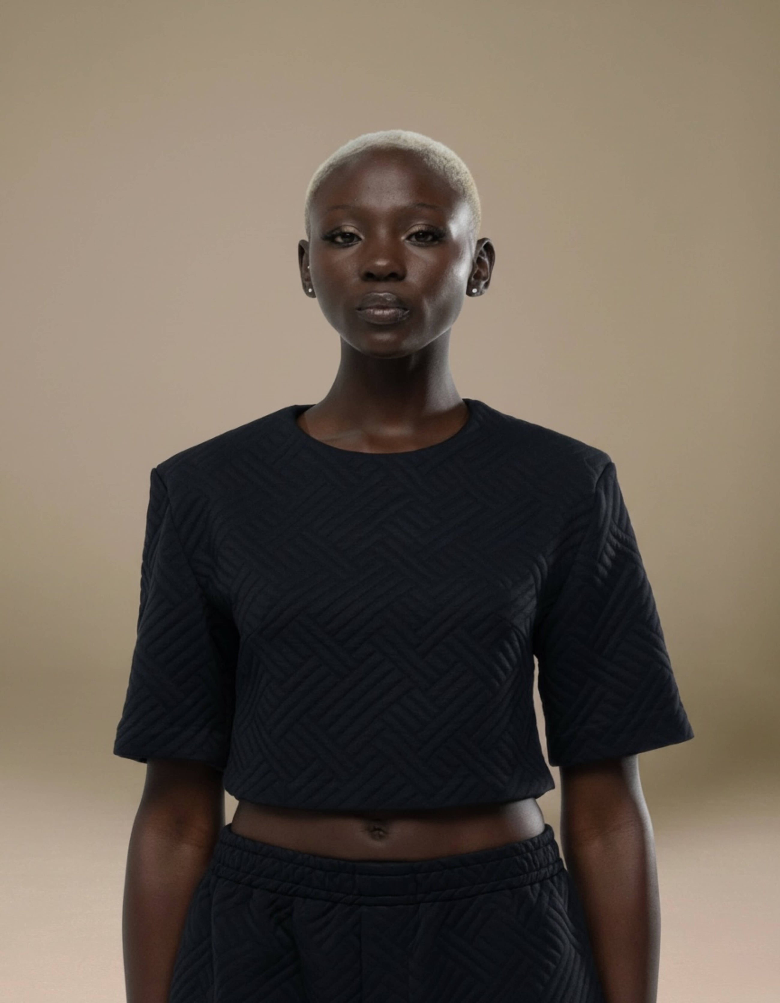 Black quilted textured crop top with structured short sleeves, luxury womenswear