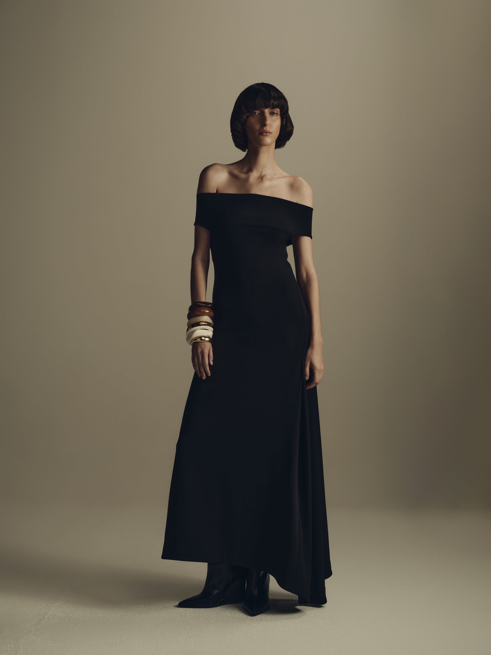 Black off-shoulder maxi dress, minimalist evening luxury womenswear styled with bangles
