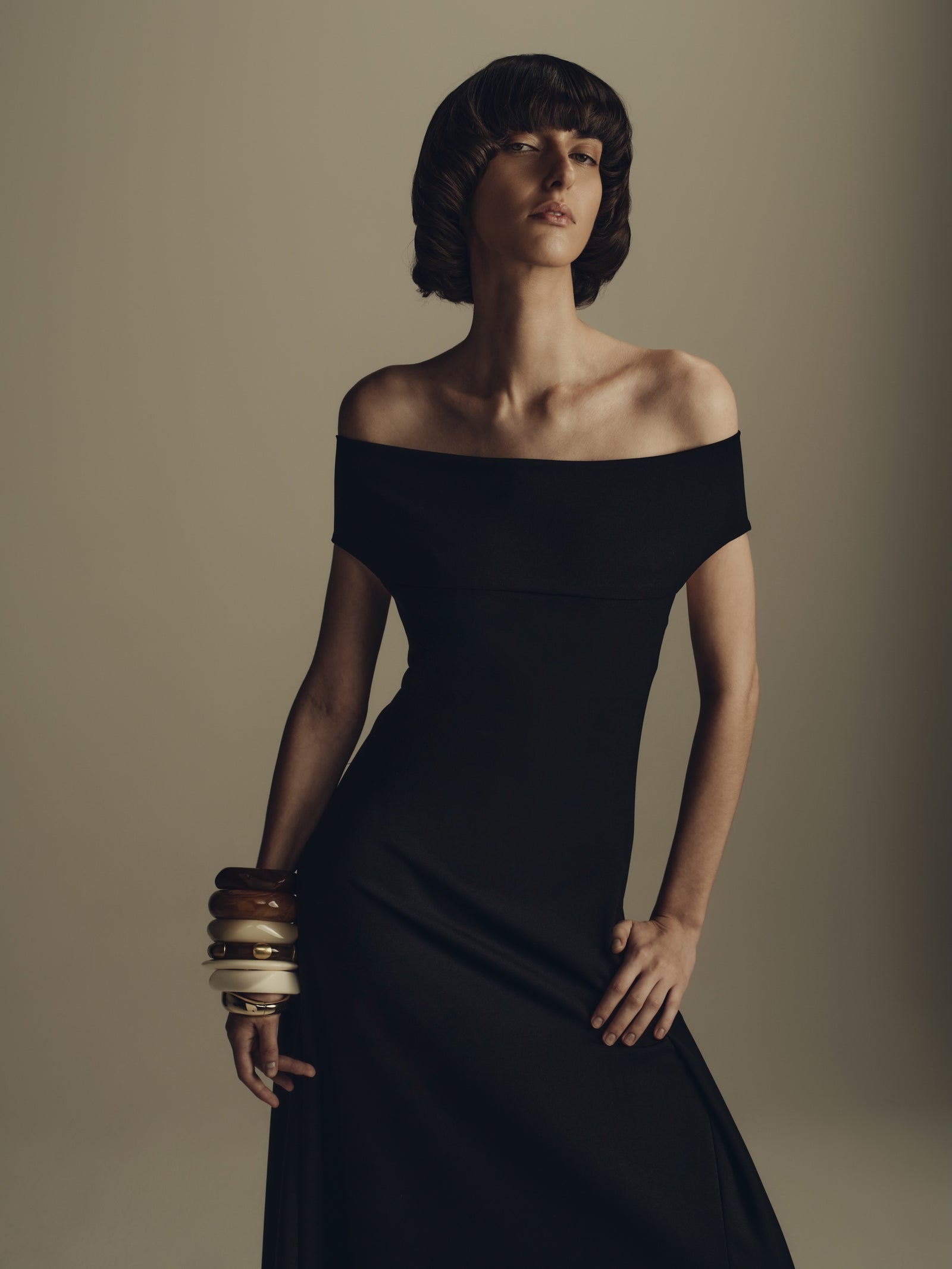 Black off-shoulder maxi dress styled with stacked bangles, evening luxury womenswear
