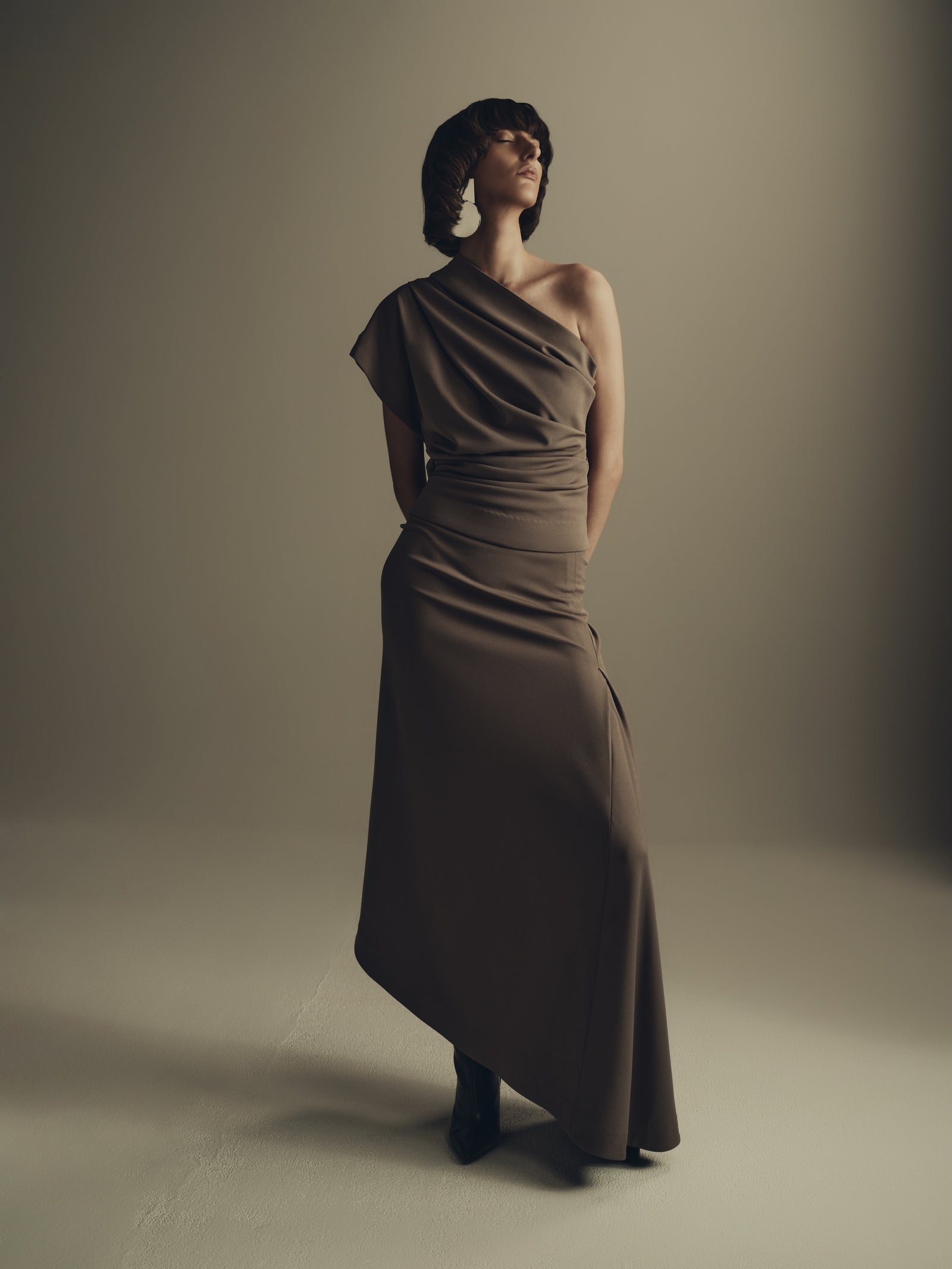 Draped one shoulder taupe maxi dress luxury womenswear campaign

