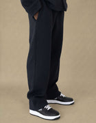 Black quilted wide-leg trousers with geometric texture, styled with sneakers
