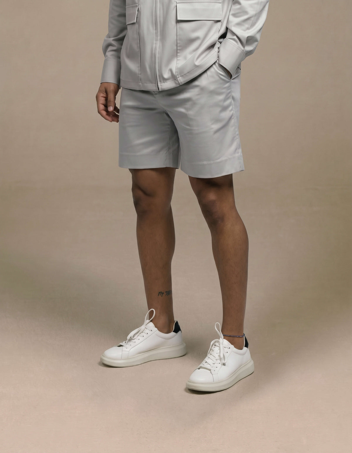 Tailored minimalist light grey shorts styled with matching jacket
