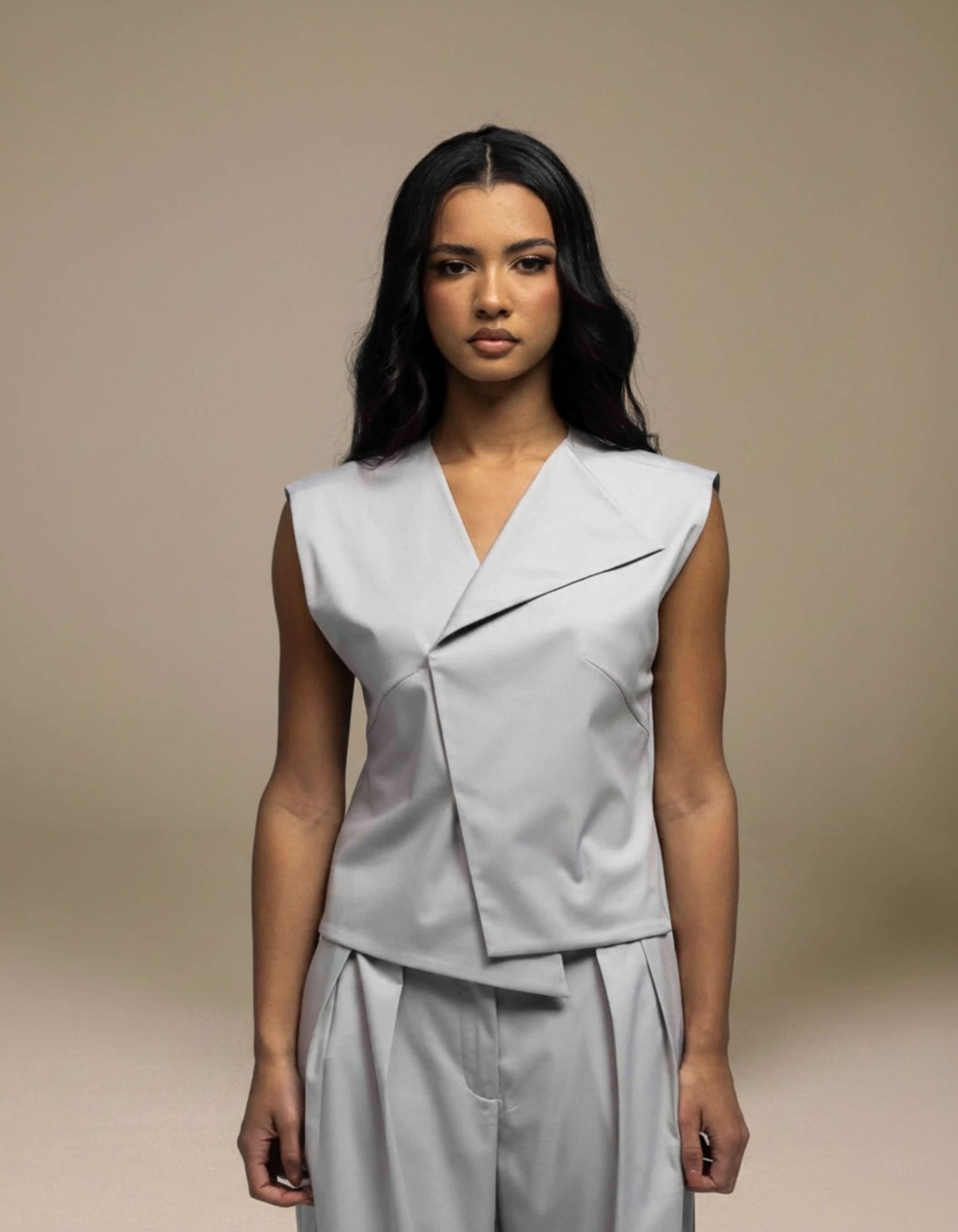 Sleeveless tailored grey top with angular wrap lapel detail, luxury womenswear
