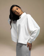 White oversized balloon-sleeve shirt styled with silver satin midi skirt
