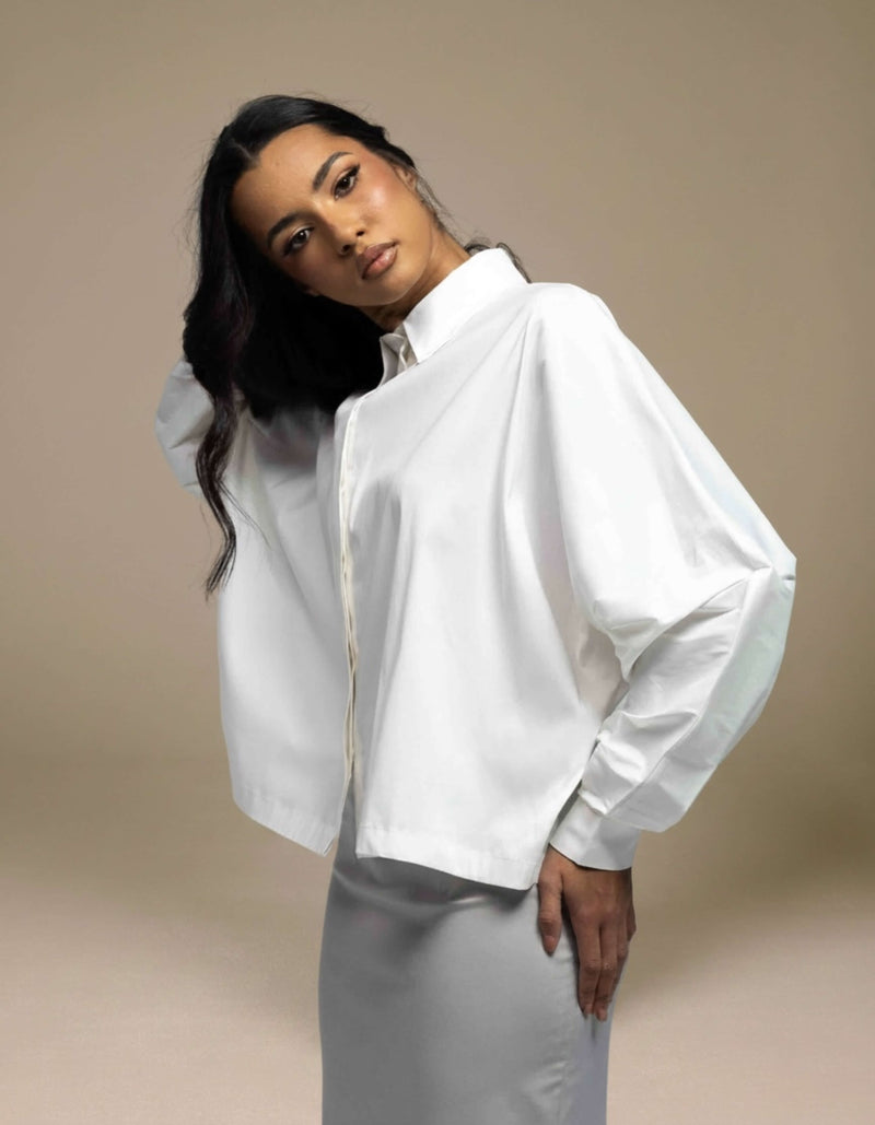 White oversized balloon-sleeve shirt styled with silver satin midi skirt
