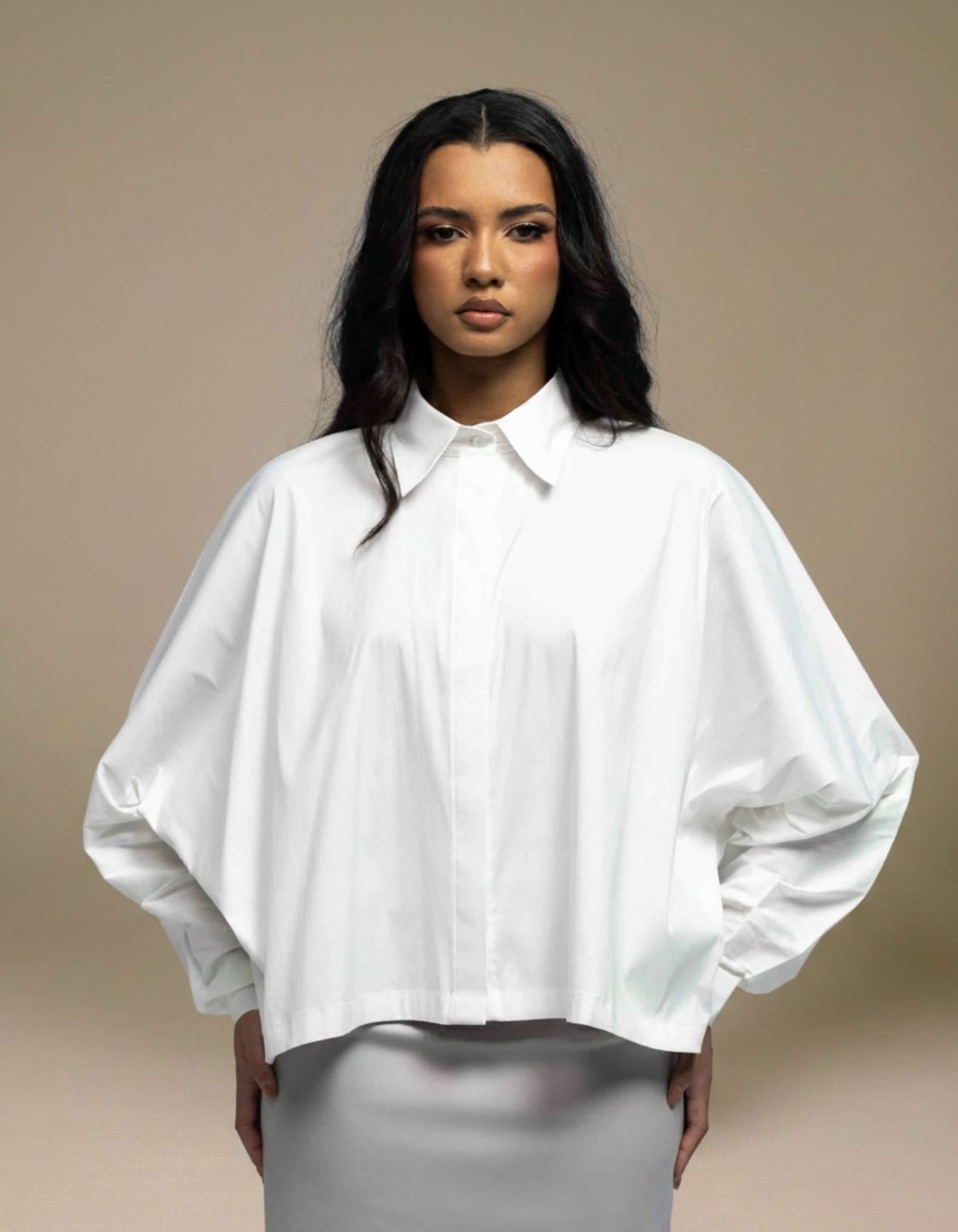 Oversized white cropped shirt with batwing sleeves, minimalist luxury womenswear
