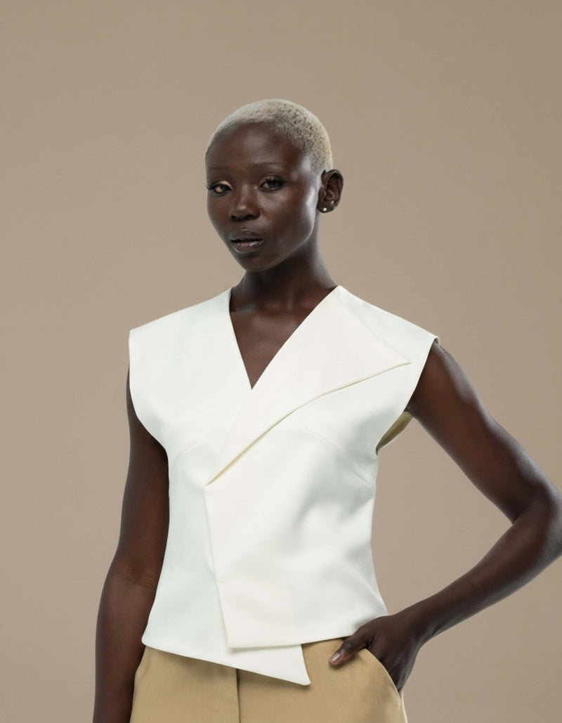 Sleeveless ivory structured top with asymmetric folded lapel detail
