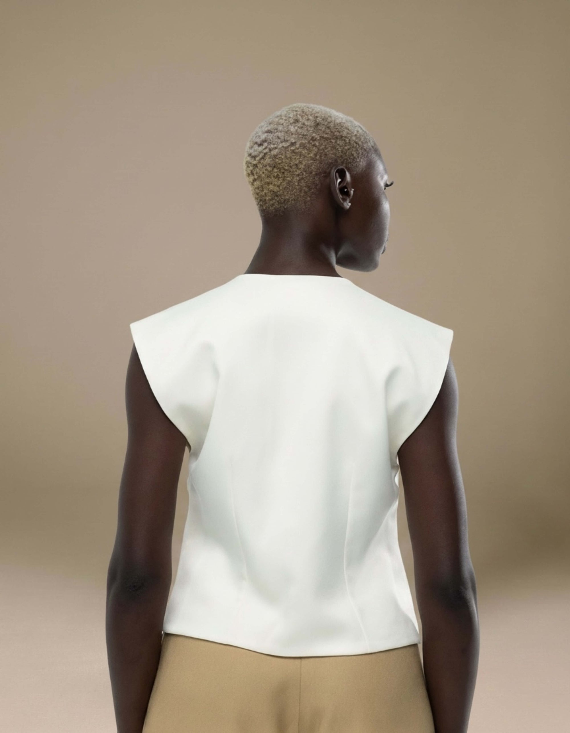 Ivory sleeveless structured top with sharp shoulder detail, luxury womenswear
