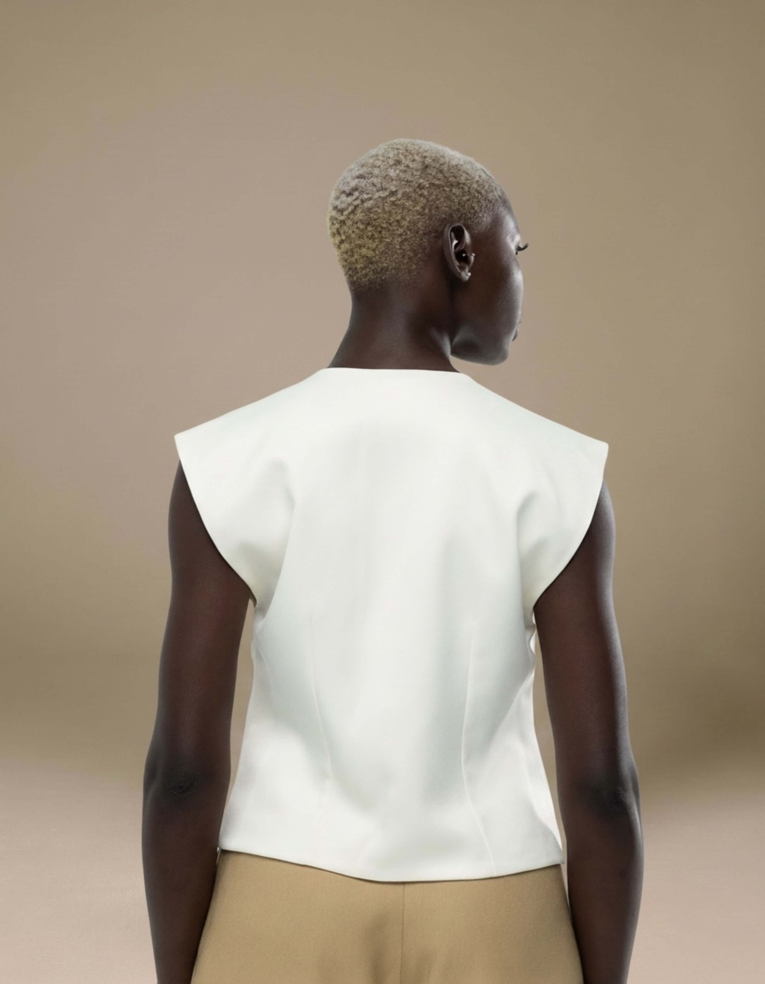 Ivory sleeveless structured top with sharp shoulder detail, luxury womenswear
